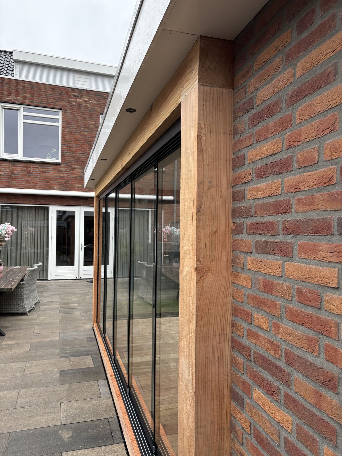 Detail aansluiting glazen wand op bakstenen muur