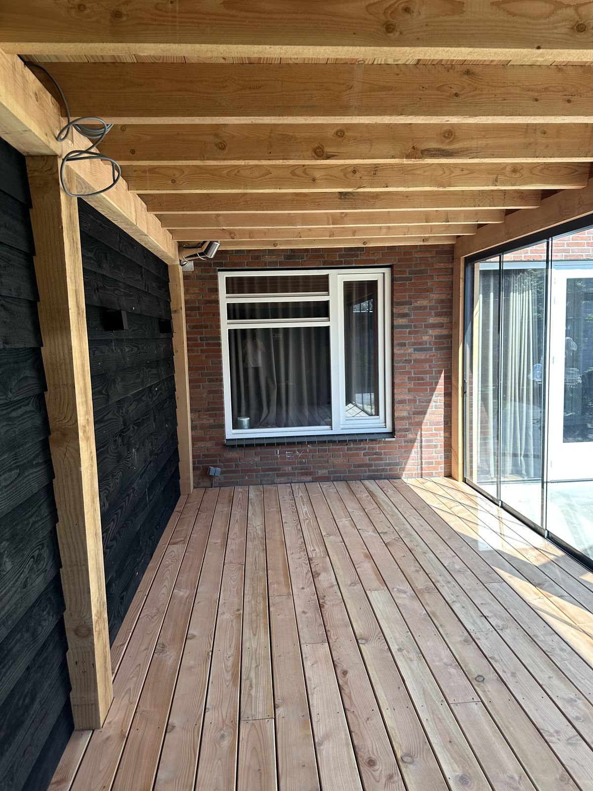 Interieur met zwarte wand en Douglas balkenconstructie